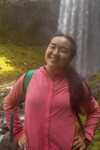 Kyla Zhang standing in front of a waterfall