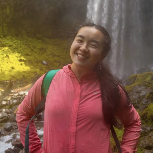 Kyla Zhang standing in front of a waterfall